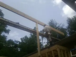 Carpenter setting a ridge beam over a new addition frame — Ice Dam Removal by Roofing Brothers in Bensenville
