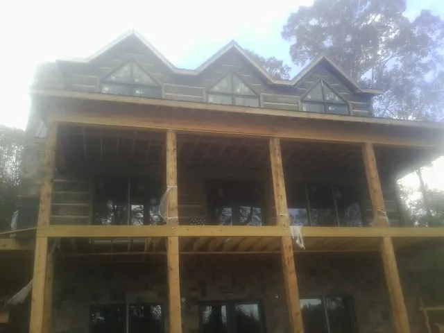 Dormers and porch framing on a large log home under construction — Roof Coating work by our crew in Bensenville