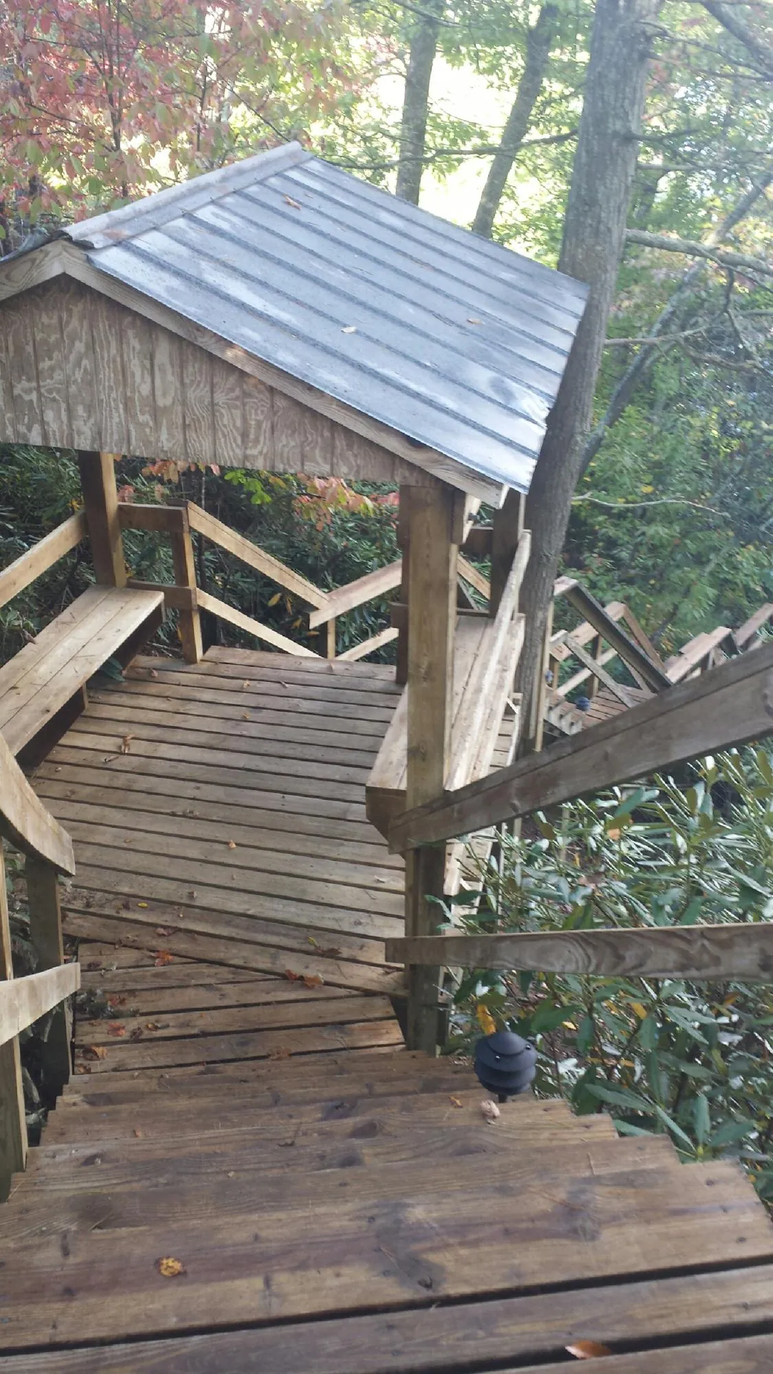 Metal roofed shelter over wooden steps on a wooded walkway — Skylight Repair & Installation work by our crew in Bensenville